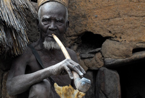 Taneka tribal man with a long pipe